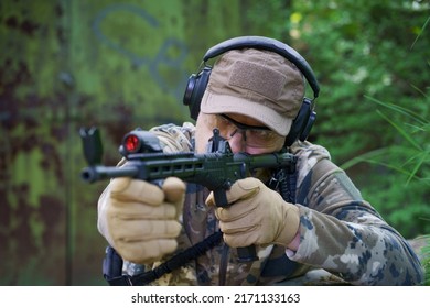 Civil Police Man In Tactical Training Course. Shooter With A Gun In Military Uniform Tactical Hearing Protector Headset. Police Training In Shooting Gallery With Weapon. Selective Focus On Hand.