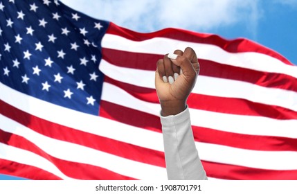 civil rights, equality and power concept - hand of african american woman showing fist over flag of united states background