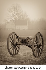 A Civil War Cannon With A Farm House In The Background At Cold Harbor