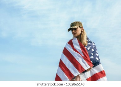 Civilian Woman In Her Husband's Military Cap. A Widow With A Flag Of The United States Left Without Her Husband. Memorial Day To Fallen Soldiers In The War. May 27th Is A Memorial Day.