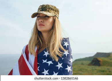 Civilian Woman In Her Husband's Military Cap. A Widow With A Flag Of The United States Left Without Her Husband. Memorial Day To Fallen Soldiers In The War. May 27th Is A Memorial Day.