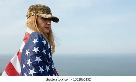 Civilian Woman In Her Husband's Military Cap. A Widow With A Flag Of The United States Left Without Her Husband. Memorial Day To Fallen Soldiers In The War. May 27th Is A Memorial Day.