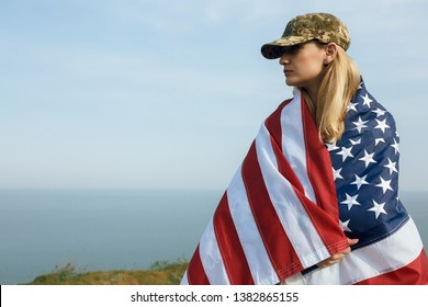 Civilian Woman In Her Husband's Military Cap. A Widow With A Flag Of The United States Left Without Her Husband. Memorial Day To Fallen Soldiers In The War. May 27th Is A Memorial Day.