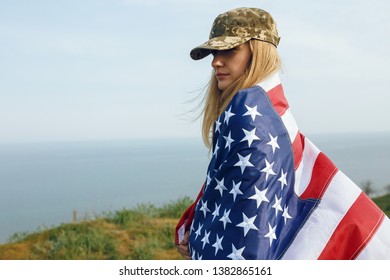 Civilian Woman In Her Husband's Military Cap. A Widow With A Flag Of The United States Left Without Her Husband. Memorial Day To Fallen Soldiers In The War. May 27th Is A Memorial Day.