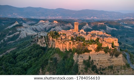 Civita di Bagnoregio, aerial view of ancient Italian city standing on top of a plateau, illuminated by setting sun. Famously known as ‘the dying city’. City on rock over Tiber river valley.