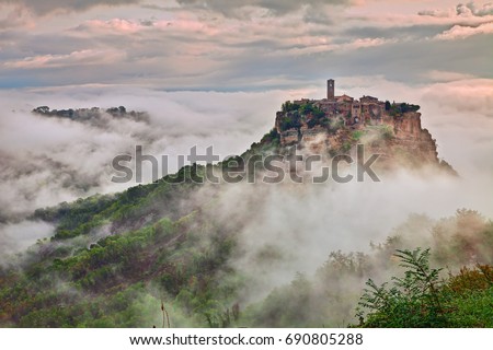 Civita di Bagnoregio, Viterbo, Lazio, Italy: picturesque landscape at dawn of the ancient village shrouded in fog on the steep tuff hill