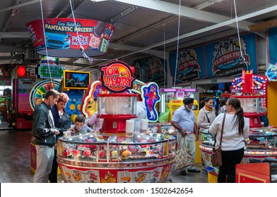 Clacton, UK - 07 Sepember 2019: Visitors To Clacton Pier In Essex, Try To Win Prizes On The Tom And Jerry Penny Pusher Machine.