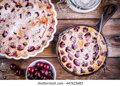Clafoutis cherry pie on rustic wooden background