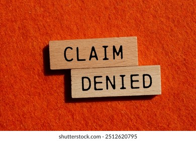 Claim denied message written on wooden blocks with orange background. Conceptual claim denied symbol. Copy space.