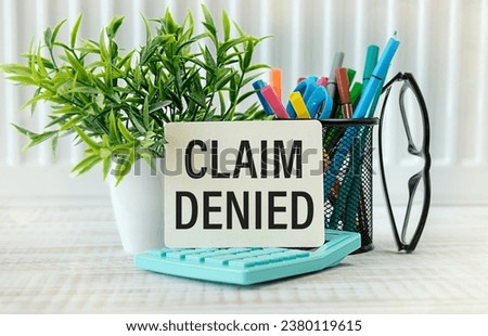Claim denied. text on paper on a notepad on the table
