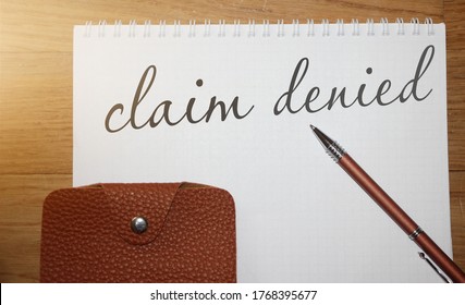 Claim Denied Words On Copybook Page, A Pen And Leather Wallet On Wooden Table. Business Sponsorship Or Insurance Payment Reject Concept.