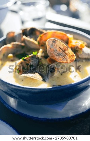 Clam chowder in a bowl with lots of in shell clams