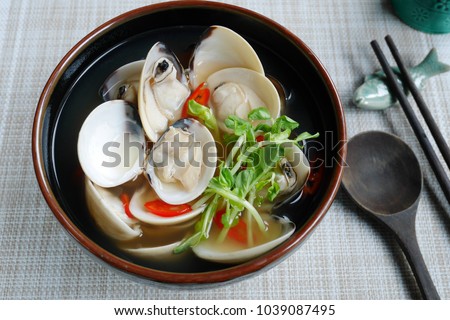clam Miso soup or Asari Miso soup ,japanese simple style cooking ,broth asari clam soup sprinkle with chopped chilli and pea sprout /japanese food