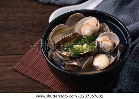 Clam soup. Close up of delicious homemade food in a bowl on wooden table background.