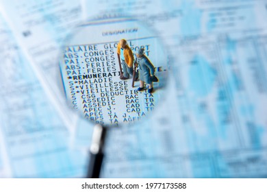 Clamart, France - April 25, 2021: French Payroll Seen In Detail Through A Magnifying Glass Showing Social Security Contributions For Retirement And Sickness, With Small Figurines Of The Elderly