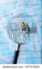 Clamart, France - April 25, 2021: French Payroll Seen In Detail Through A Magnifying Glass Showing Social Security Contributions For Retirement And Sickness, With Small Figurines Of The Elderly