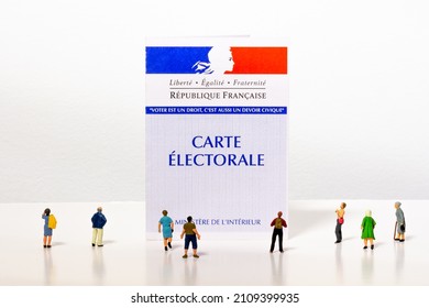 Clamart, France - January 19, 2022: Tiny citizen figurines looking at a French electoral card. Each voter receives an elector card allowing them to vote in elections in France