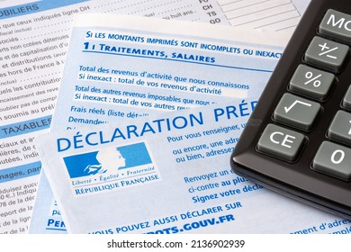 Clamart, France - March 18, 2022: French pre-filled income tax return with the page about income from salaries, treatments, pensions and annuities, and a calculator