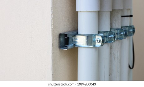 Clamp the conduits on the wall. Installation of IMC plastic conduit on the wall for electrical work that meets safety standards with copy space. Selective focus