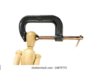 A Clamp Squeezing Tightly On The Head Of A Wooden Man.  A Great Concept Shot For Headaches Or Stress.