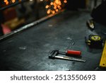 Clamp and working tools on dark workbench in locksmith workshop	