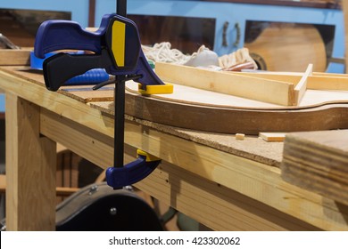 Clamping in workshop/hydraulic clamp in luthier work/hand tool /locked by clamp  - Powered by Shutterstock