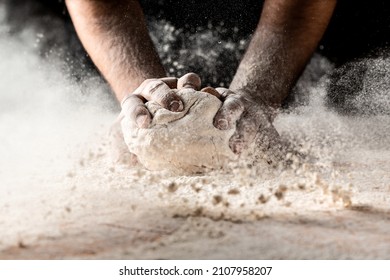 Clap hands of baker with flour. Beautiful and strong men's hands knead the dough make bread, pasta or pizza. Powdery flour flying into air. - Powered by Shutterstock