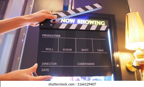  Clapper Board Or Movie Slate With Hand In Front Of Now Showing Board . It Use In Video Production Or Film Industry.