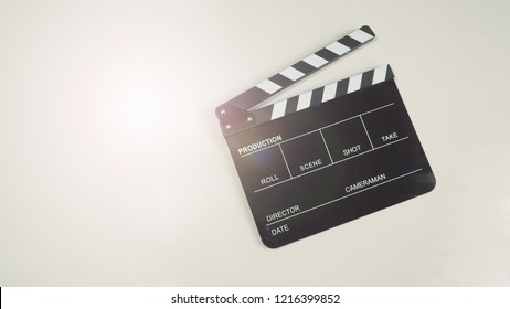 Clapper board or movie slate use in video production or movie and cinema industry. It's black color with flare light on white background.  - Shutterstock ID 1216399852
