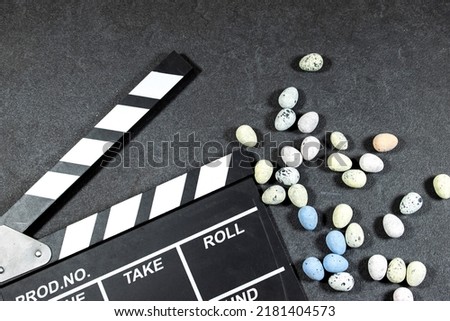 clapper board of video cinema in studio with easter eggs on grunge gray background