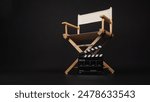 Clapper board with white director chair on black background.