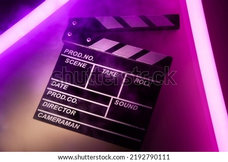 Clapperboard movie slate on Glowing neon lighting background. video director making cinema film. Film clapper design element. filmmaker clapper board to make video film