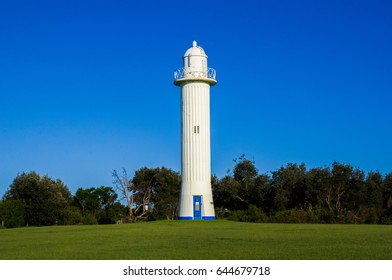 The Clarence River Lighthouse at Yamba, Australia. A beautiful white historical lighthouse against clear blue sky.