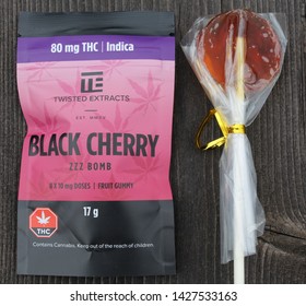 Clarenville Newfoundland Canada - June 18, 2019 - Cannabis Black Market Edibles Prepackaged For Public Sale. ZZZ Bomb Black Cherry Fruit Gummies And Orange Flavored Lollipop Or Sucker Candy.