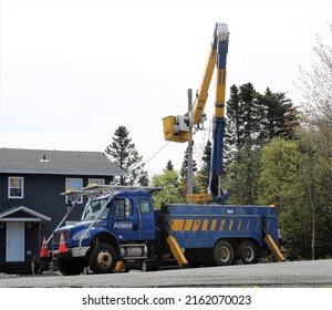 Clarenville Newfoundland And Labrador - May 30, 2022 - Hydro Energy Company Newfoundland Power Cherry Picker Truck With Crane Extended And Crew Making Repairs After A Power Outage.