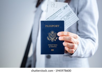 Clarksburg, MD, USA 03-29-2021: A caucasian businesswoman is showing her travel documents at airport including US passport, boarding pass and COVID vaccination record card as a proof of immunization.
