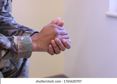 Clasped Hands Of A Military Health Care Provider In Uniform During The Covid-19 Pandemic.