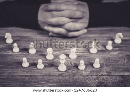 Clasped hands planning strategy with chess figures . Selective focus