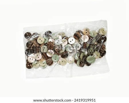 clasper , colored plastic Buttons in a clear plastic bag isolated on white background.