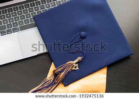 Class of 2021 graduation tassel and cap celebration with a modern computer for virtual learning during covid 19 pandemic