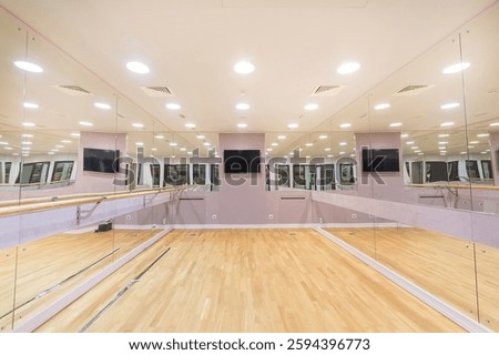 A class for dancing and ballet classes. Mirrored walls, parquet floors and a TV. Ballet barre.