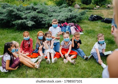 A class of masked school children is engaged in outdoor training during the epidemic. Back to school, learning during the pandemic - Powered by Shutterstock