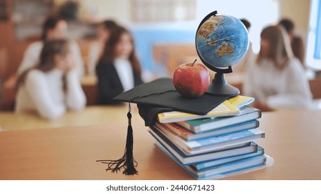 Class with students against background of books, apple, globe and graduation cap. - Powered by Shutterstock