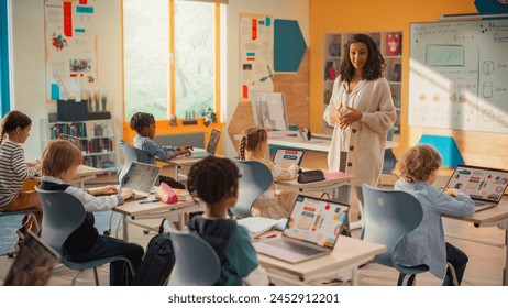 Class of Young Multiethnic Children Using Laptop Computers while Studying Math and Geometry in Grade School. Happy Female Teacher Explains Shapes and Measurements to Smart Boys and Girls - Powered by Shutterstock