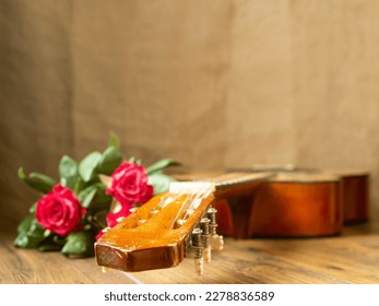 Classic acoustic guitar on a wooden floor and bouquet of red rosses. Expression of gratitude and love for great music performance. Romantic background. - Shutterstock ID 2278836589