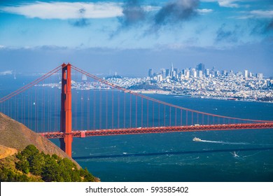 Classic aerial view of famous Golden Gate Bridge with the skyline of San Francisco in the background on a beautiful sunny day with blue sky and clouds in summer, San Fancisco Bay Area, California, USA