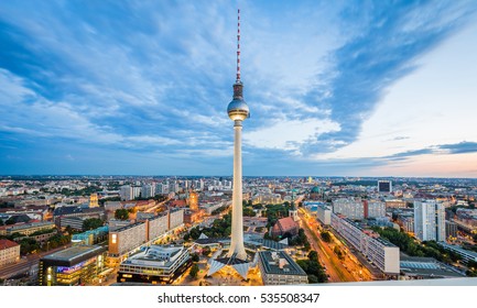 Classic aerial wide-angle view of Berlin skyline with famous TV tower at Alexanderplatz and dramatic cloudscape in beautiful twilight during blue hour at dusk in summer, central Berlin Mitte, Germany