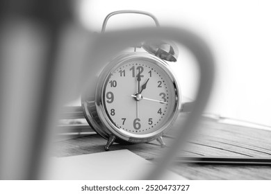 A classic alarm clock captured in black and white setting, showcasing time in an elegant and timeless manner. Perfect for conveying concepts of time management and simplicity. - Powered by Shutterstock