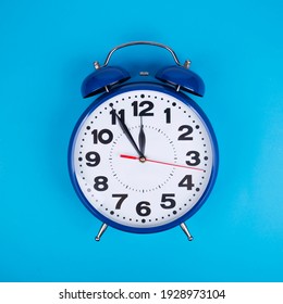 Classic alarm clock on light blue background