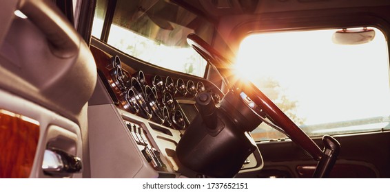 Classic American Commercial Semi Truck With Stylish Chrome Gauges Panel And Custom Luxury Wooden Steering Wheel. Luxurious And Comfortable Cabin Of 18 Wheeler Truck At Evening, Back Lit, Warm Filter.